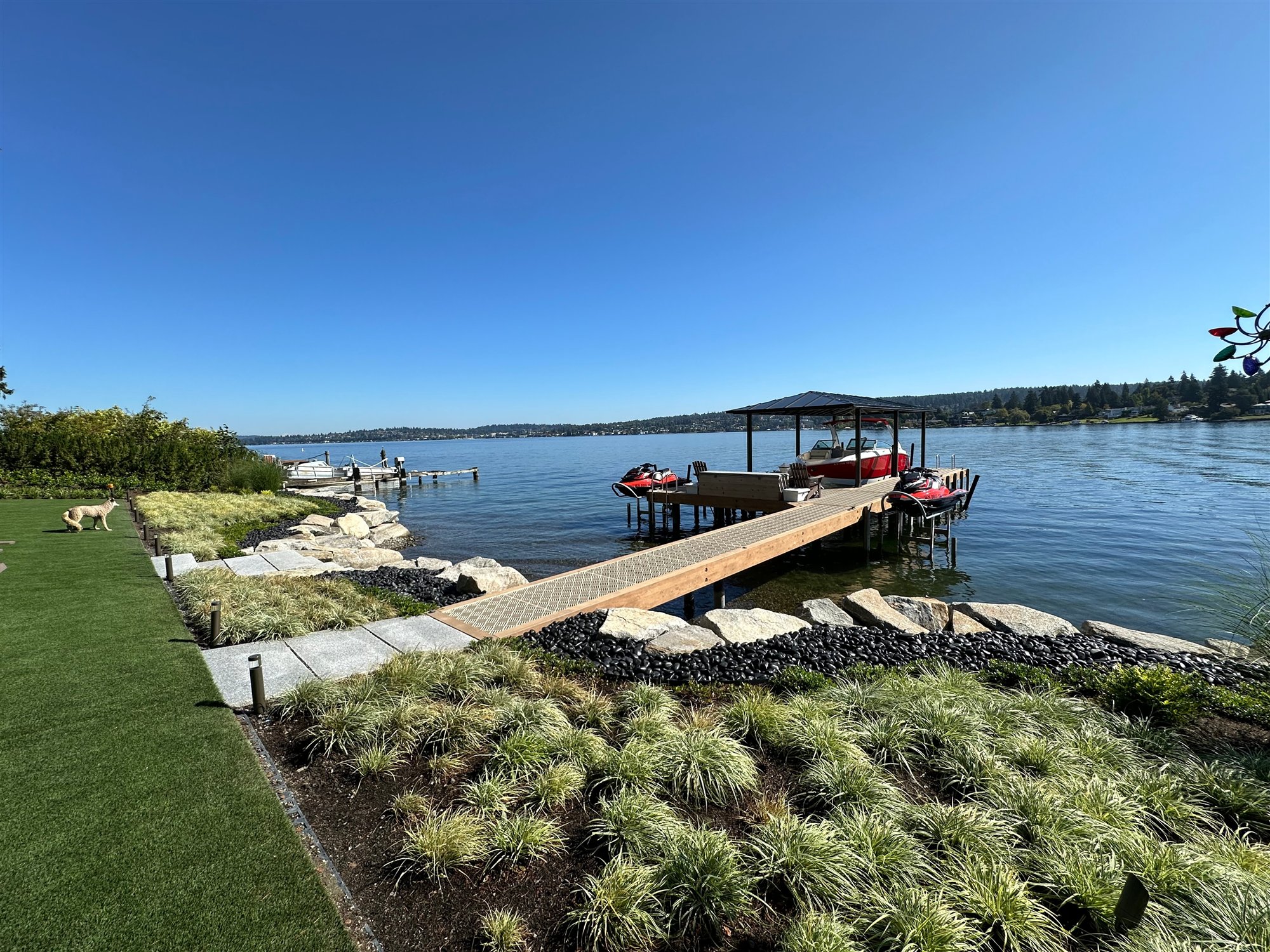 A finished WCI dock extending from a landscaped shoreline into Northwest waters