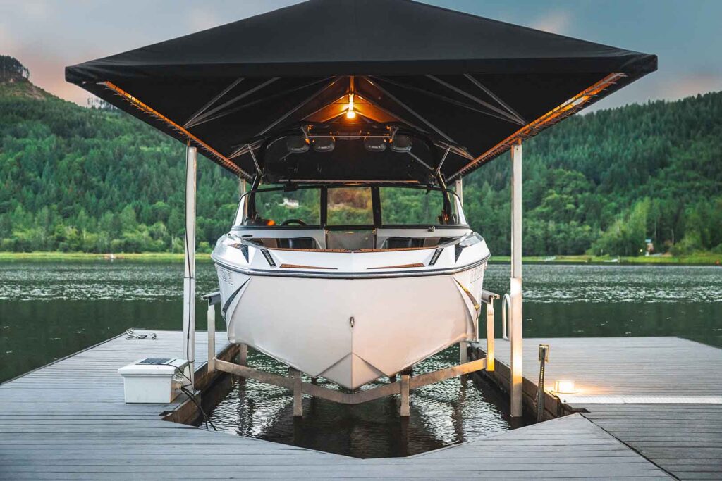 Boat protected above the water on a covered hydraulic boat lift