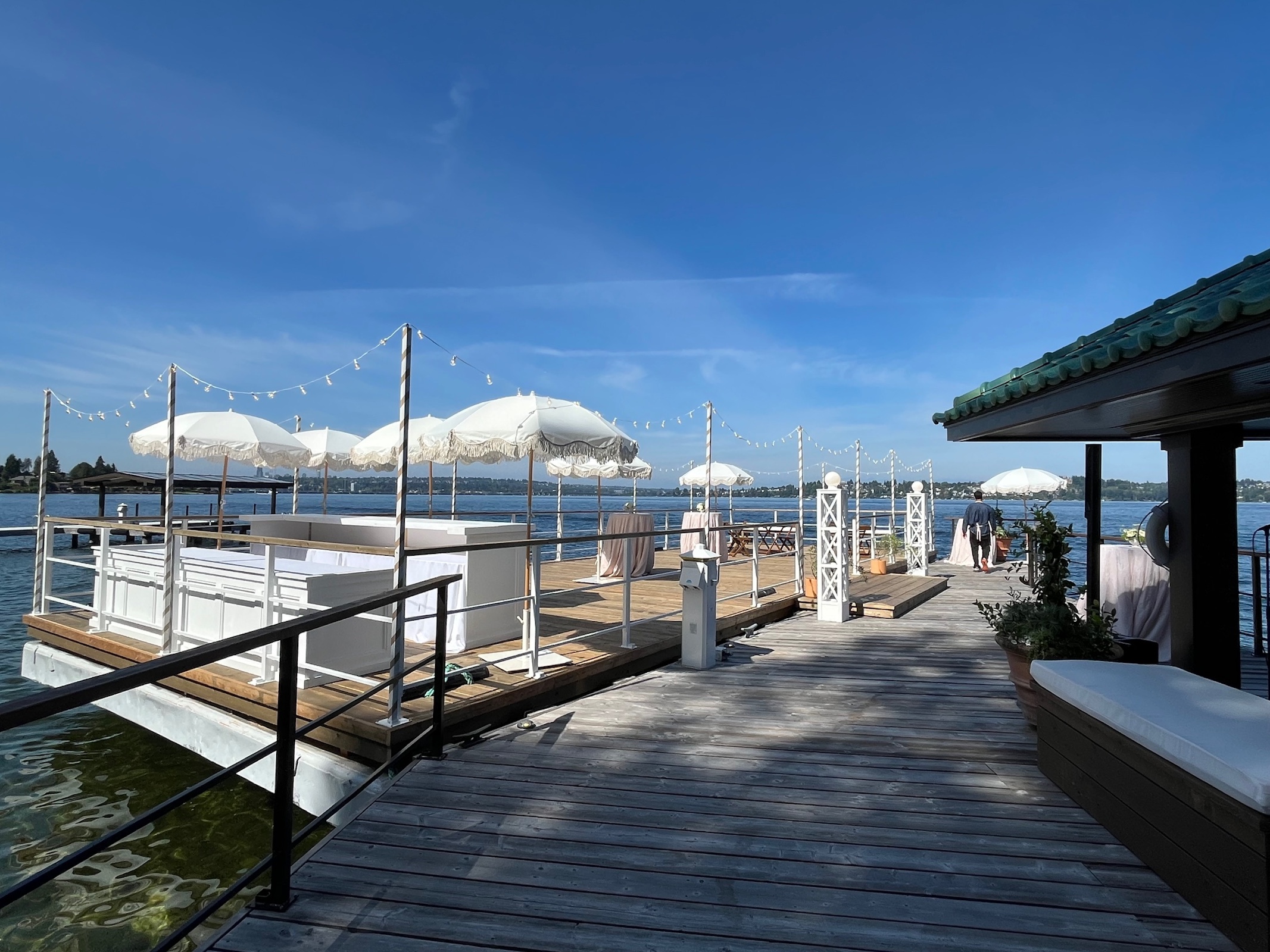 Floating wedding barge decorated with white umbrellas, string lights and reception tables