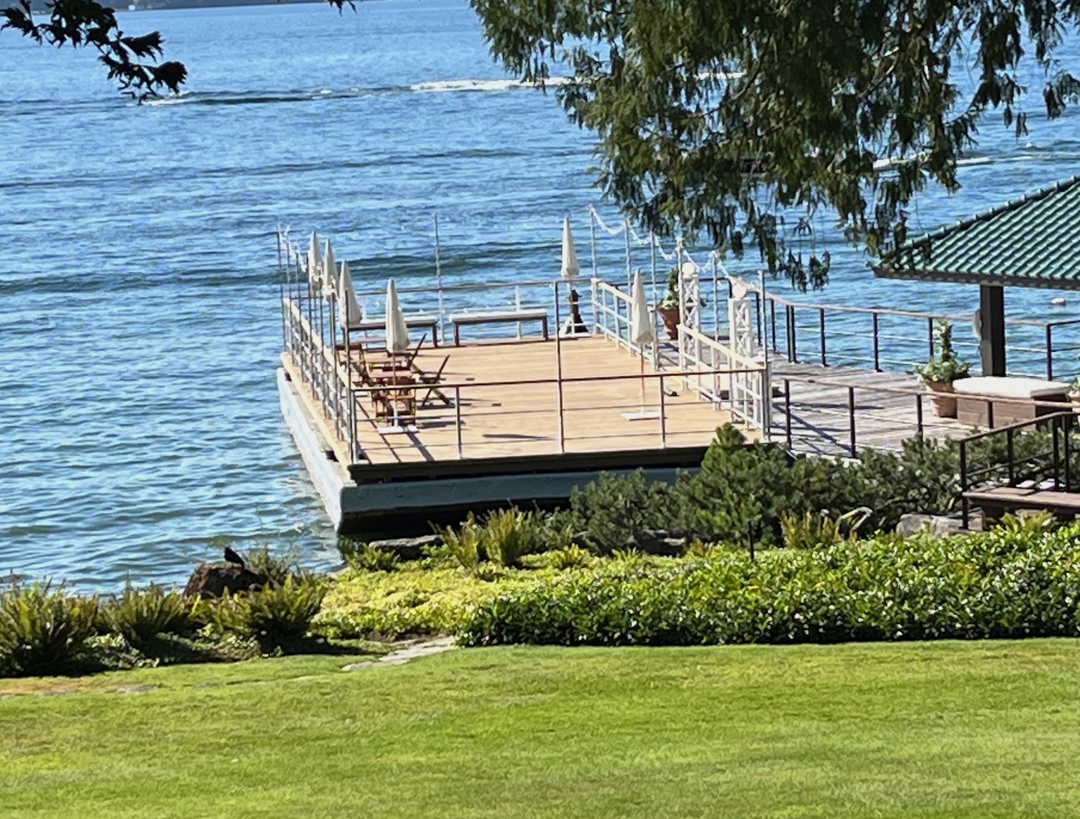 Floating wedding and party barge moored beside a landscaped Northwest waterfront property